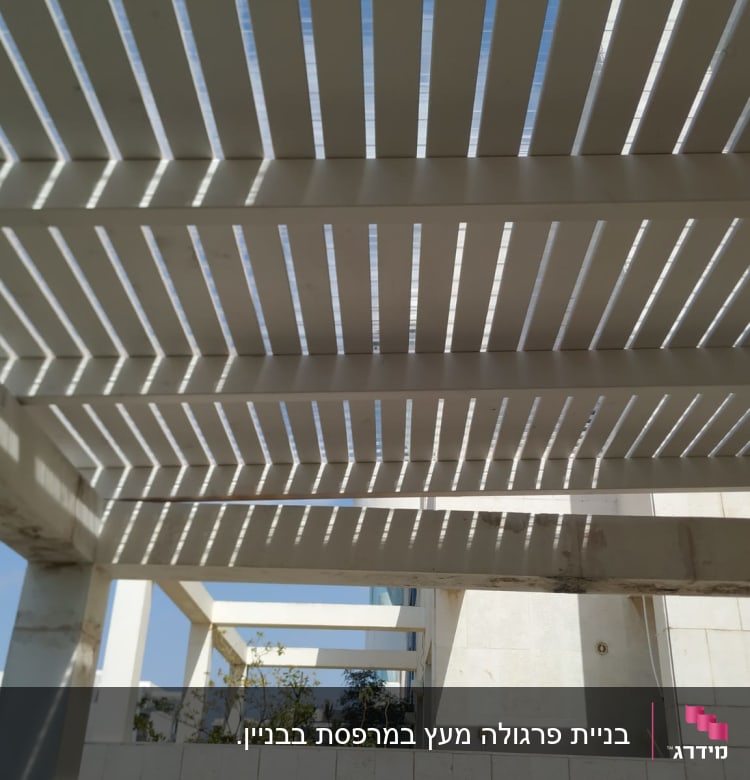 פרגולה מעץ עם קורות אופקיות וצללים
